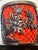 An intricately decorated Chinese-style lidded jar featuring elaborate raised floral carvings against a vibrant red...