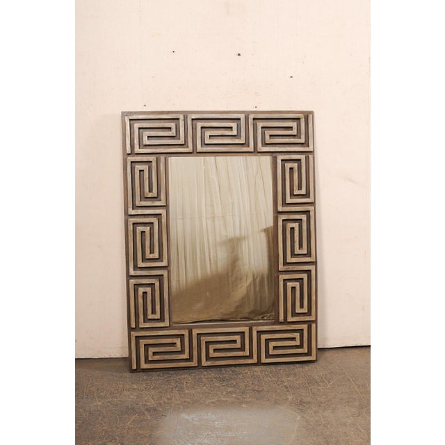 An artisan made mirror with Greek key carved motif surround from old, reclaimed wood. This custom mirror features a raised...