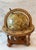 Vintage wood and paper tabletop world globe featuring detailed old world cartography, classical Latin labels, and a...