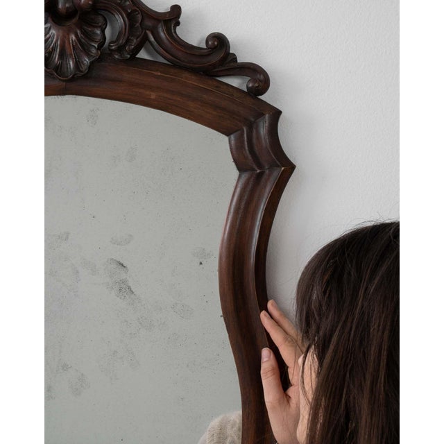 A mirror whose dark carved wood frame with scroll crest, arched gives it real character at first glance. Originating in...