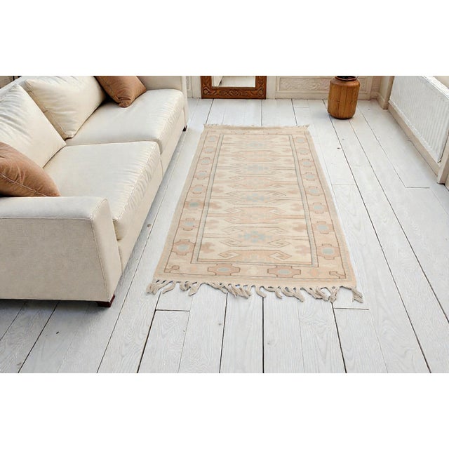 This is a vintage Turkish Oushak rug from the Mid 20th Century. The piece was hand-knotted.