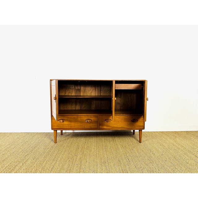 Vintage ercol scandinavian sideboard dating from the 1960s, featuring three storage doors with shelves and two drawers....