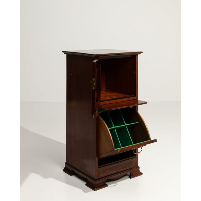 This side cabinet makes its impression through dark mahogany, drop-front door, green interior. The piece dates to 19th...
