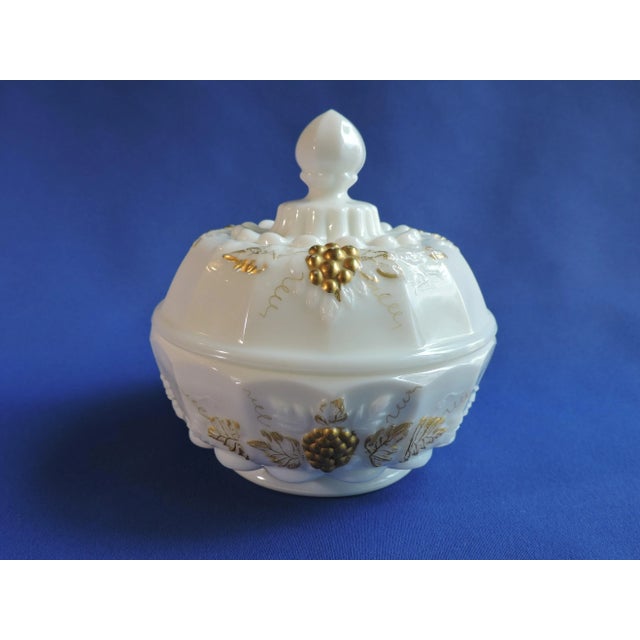This gilded milk glass covered candy jar was made by the Westmoreland Glass Co. and it is pressed glass pressed in their...