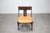 A sculptural vintage chair from Germany, dating to circa 1970, distinguished by its dark-stained wooden frame, angular...