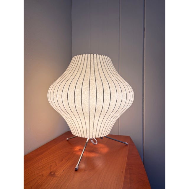 This authentic Nelson Pear Tripod Bubble Lamp is a mid-century modern accent table light designed by George Nelson for...