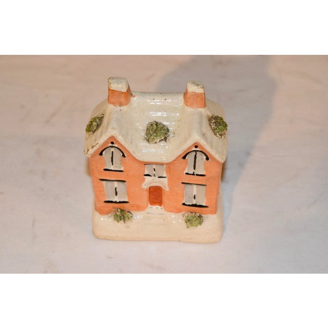 19th century Staffordshire pottery penny bank from England in the form of a cottage with flocked details. The coin slot...