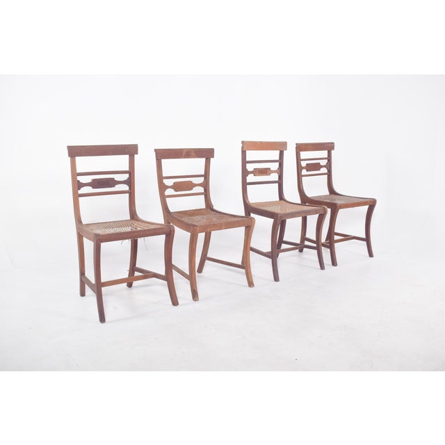 Four chairs with straw backs. Handmade, with lines inspired by the Empire style, characterised by the sobriety and...