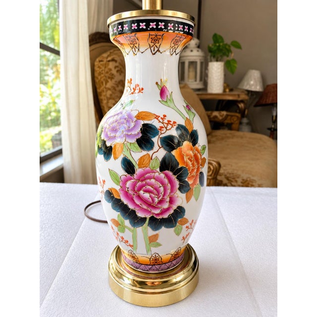 Elegant vintage table lamp featuring a beautifully decorated white porcelain body with colorful floral and botanical...