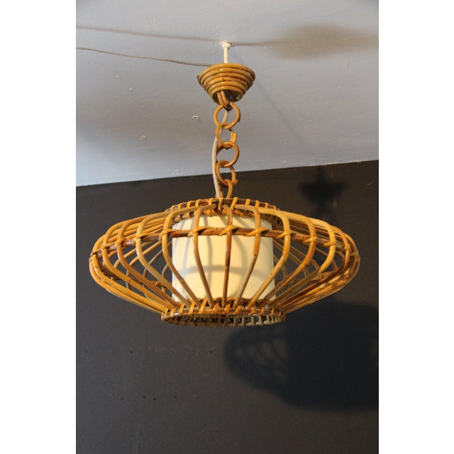 Magnificent mid-century pendant light inspired by the french riviera, entirely crafted from hand-bent rattan and woven...