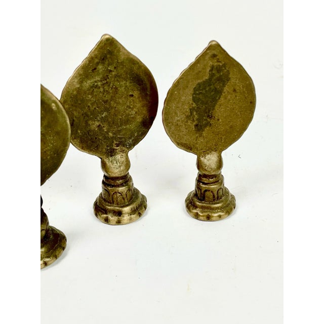 A trio of cast brass mirrors found in Nepal. These small objects mimicking flames would adorn shrines and temples to...