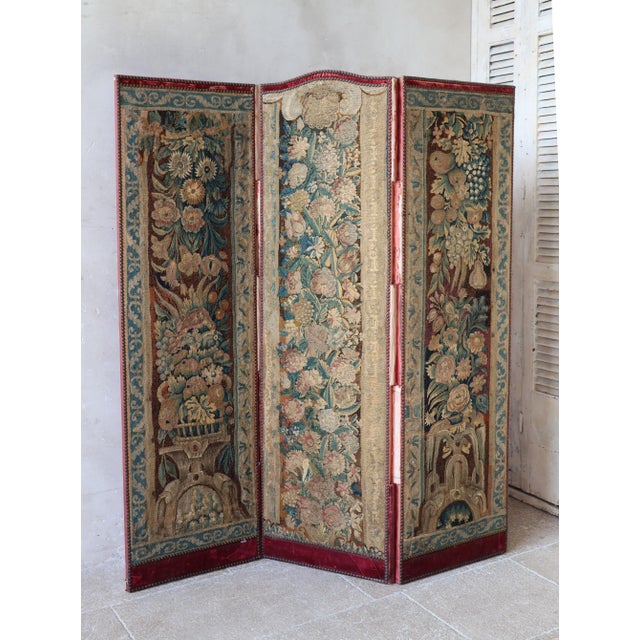 Folding screen executed with floral tapestries in Gobelin and Aubusson style (19th century). This rare three-panel folding...