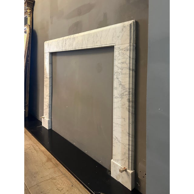 An elegant yet simple surround, executed in variegated Calacatta Italian marble. The square foot blocks supporting simple...