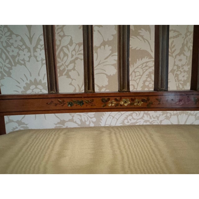 An attractive Edwardian satinwood floral painted arm chair with cane seat.