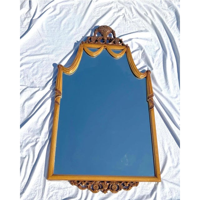 An absolutely stunning carved wood draped mirror with a crested top and a floral fretwork on the bottom. Italy, circa 1930’s.