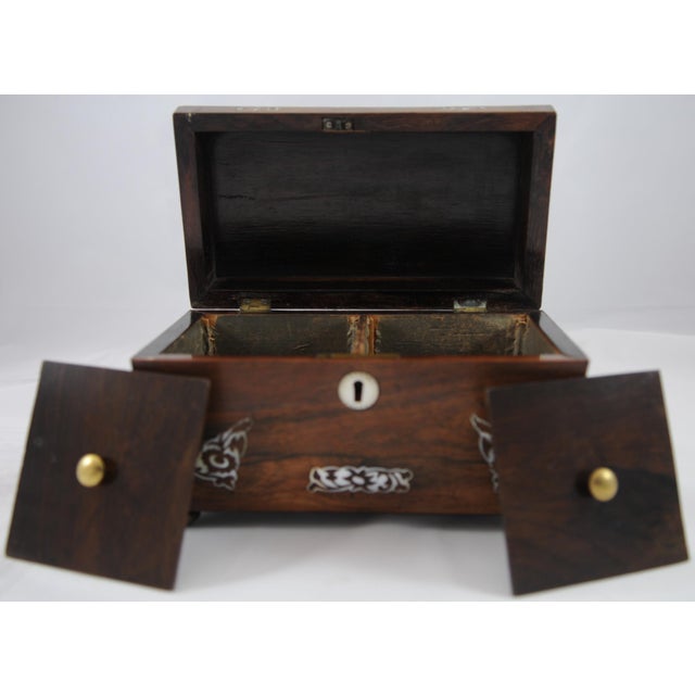Antique Rosewood and Mother of Pearl Inlay with Bun Feet and Sarcophagus Form In used condition, that comes with multiple...