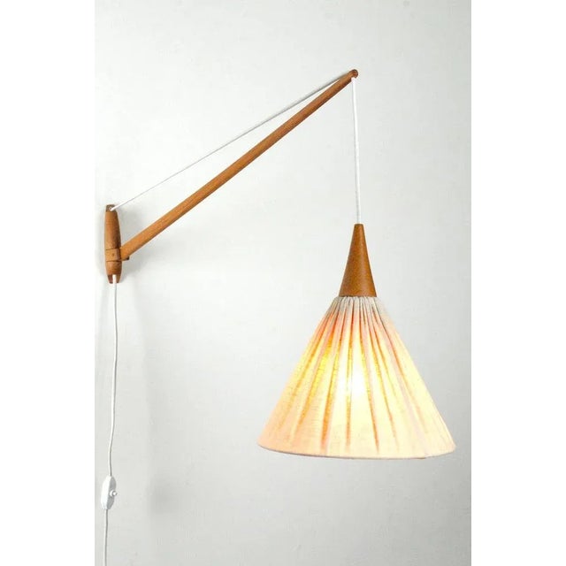 Luxus wall lamp model number 534 exists in several versions. The wood parts were made in oak or teak and the shades were...