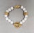 1980s goldtone spherical white resin breads with "braided" goldtone beads and a single goldtone leaf bead in the center...