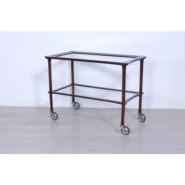 Classic serving cart of the 1950s. Wooden structure presumably dyed beech, with glass tops and four well-functioning...
