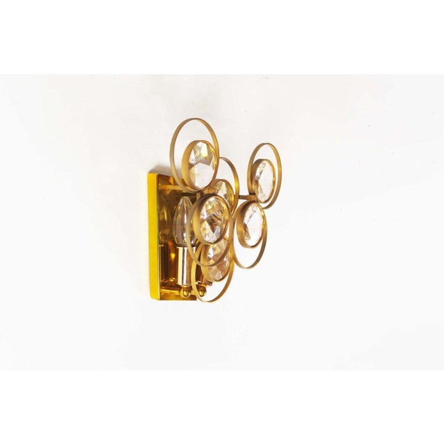 Wonderful and uncommon polished brass and crystal glass wall lamp by Palwa. Two lamps in the back surrounded by 6 large...