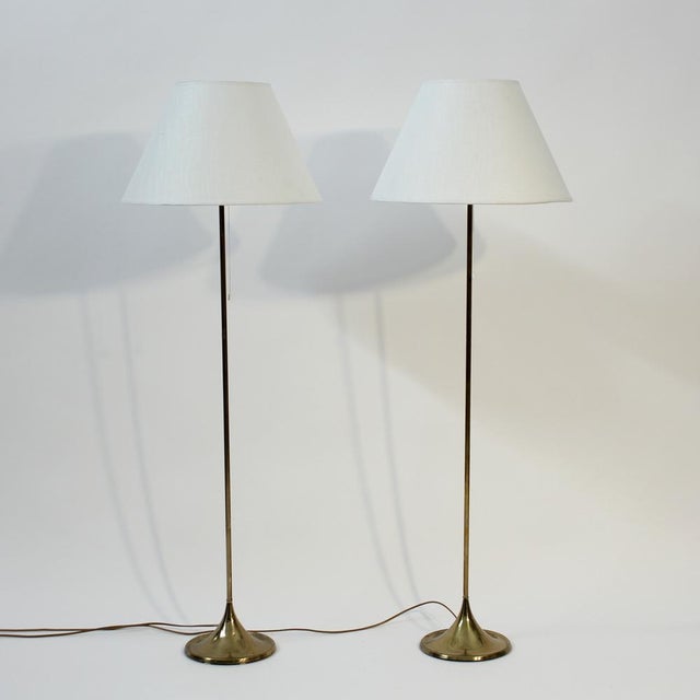 Pair of 1960s Bergboms floor lamp, model G-25. Brass stem on top of a round, almost cone shaped brass base. Mounted with...