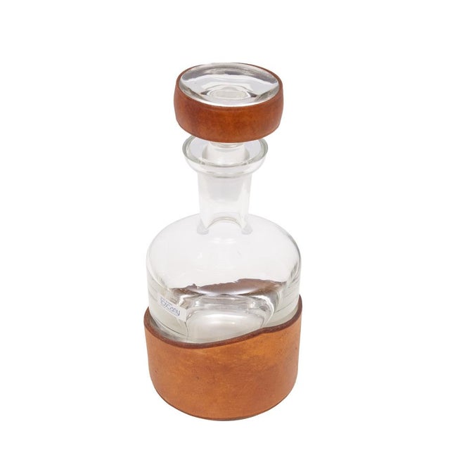 Thick hand blown Glass Whiskey Bottle . rapt with Cognac color Leather ,hand Stich together . top of the line of the...