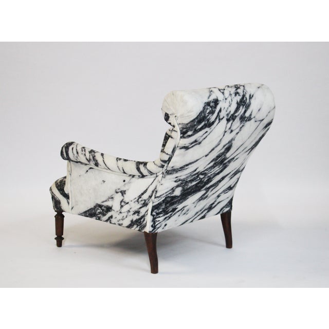 Upholstered Scroll Back Arm Chair in Marble Patterned Fabric and Exposed Wooden Legs.