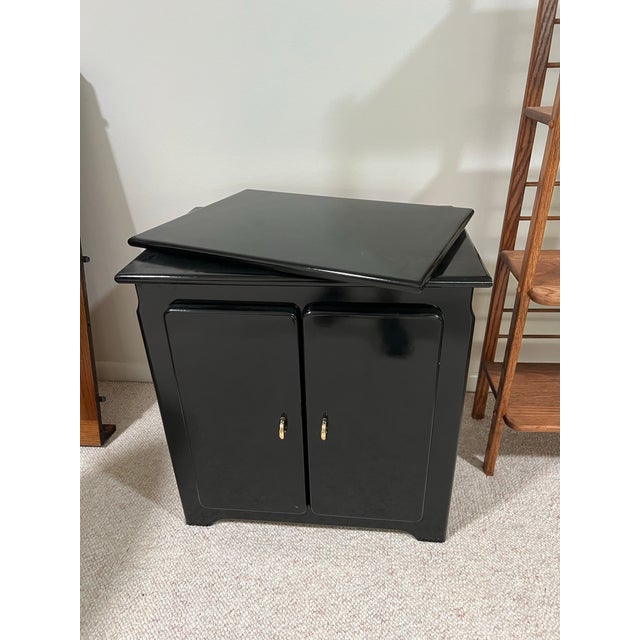 Vintage 1980s black laminate/lacquer swiveling TV media cabinet. The distinctive top panel is designed to rotate, allowing...