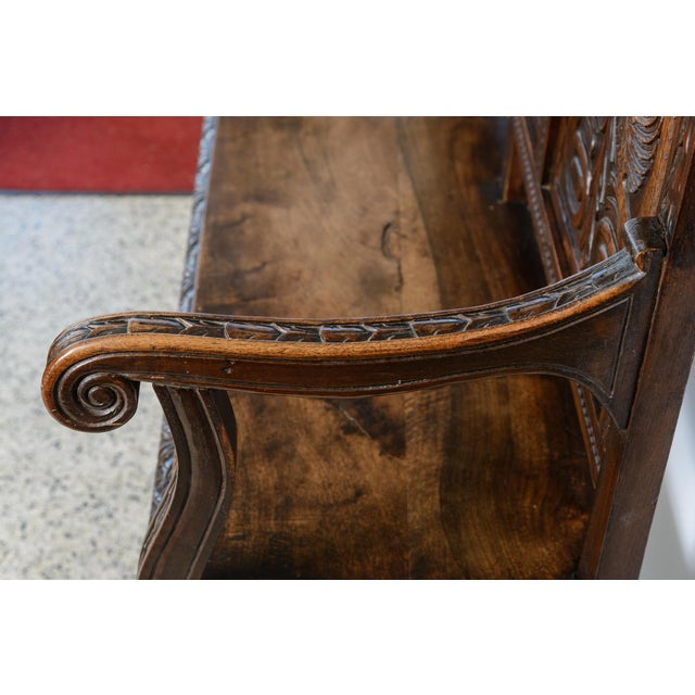 Antique walnut carved European hall bench with metal stretcher, three panel back and a double eagle carved on one of the...