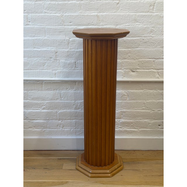 A beautiful vintage wood pedestal with a warm, honey-toned finish and beautifully carved architectural detailing. The...