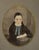 A striking vintage walnut-framed portrait featuring a hand-colored oval image of a young girl, presented in a richly...