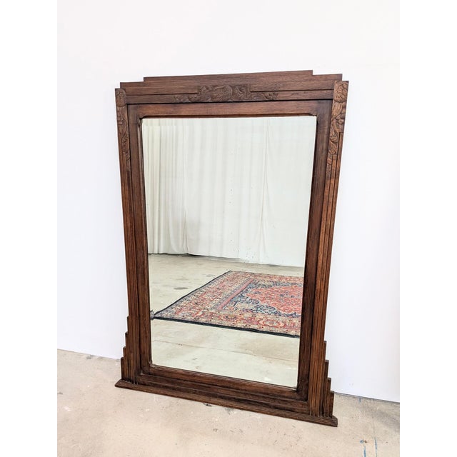 Exquisite antique mirror with a carved oak frame featuring a skyscraper motif typical of the Art Deco period in France....
