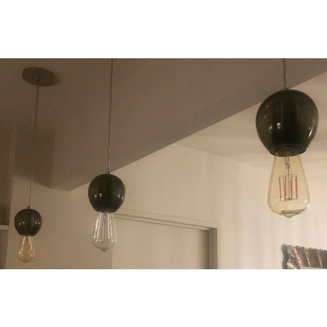 Tracy Glover An industrial modern alternative to lighting. Exposed bulb in smoke colored hand-blown glass. Globe round...
