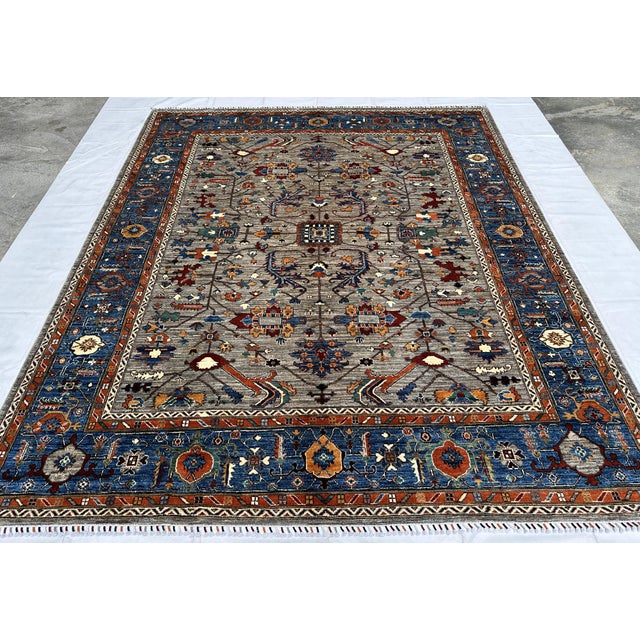 This hand-knotted Khotan-style rug features a refined allover lattice of diagonal vines and angular palmettes in rust,...