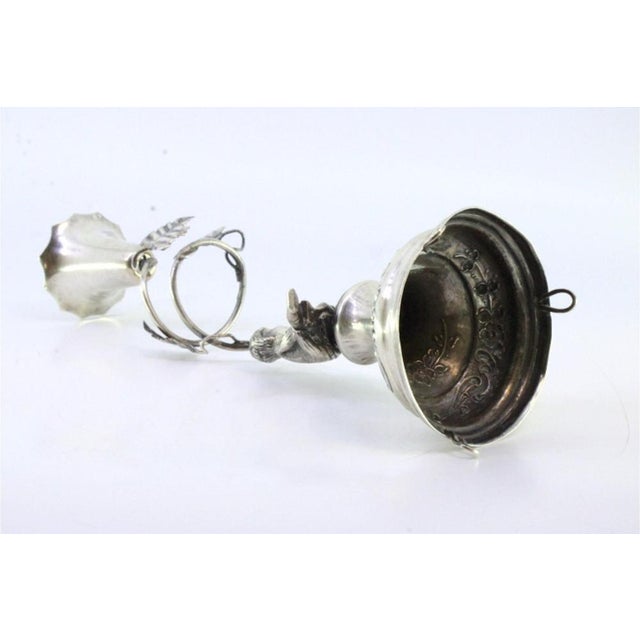 Silver toothpick holder with chalice supported on acanthus and child sitting on the plinth with floral motifs engraved on...