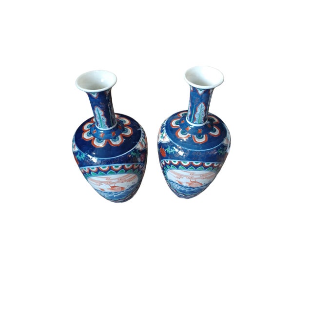 Vintage pair of nlie long neck Asain Koi vases. Mostly blue in color with floral and gold decoration. Signed on bottom