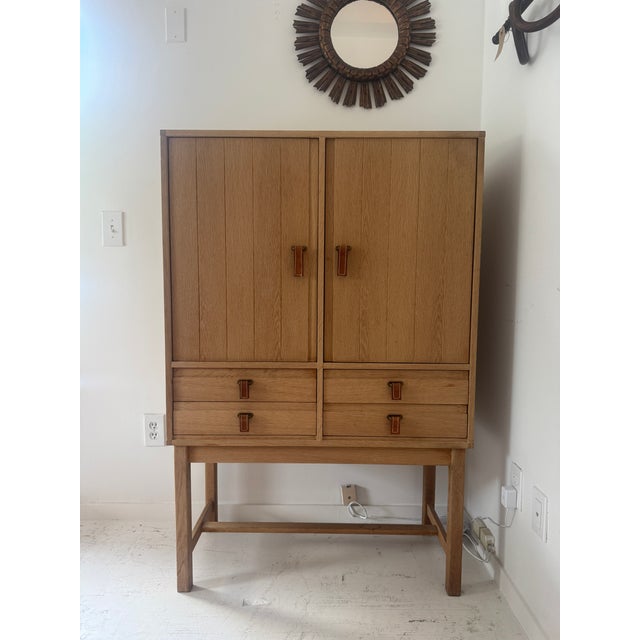 Light oak bar cabinet by Kurt Ostervig, 1960. This Danish wooden cabinet produced by K.P Mobler has two (2) doors that...