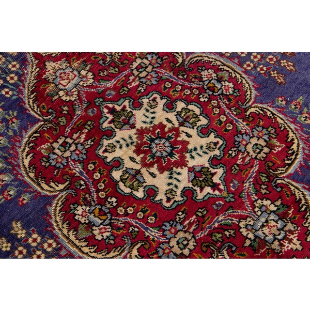 Beautiful vintage Persian Tabriz hand-knotted wool rug with a navy blue color field. This piece has a purple frame and...