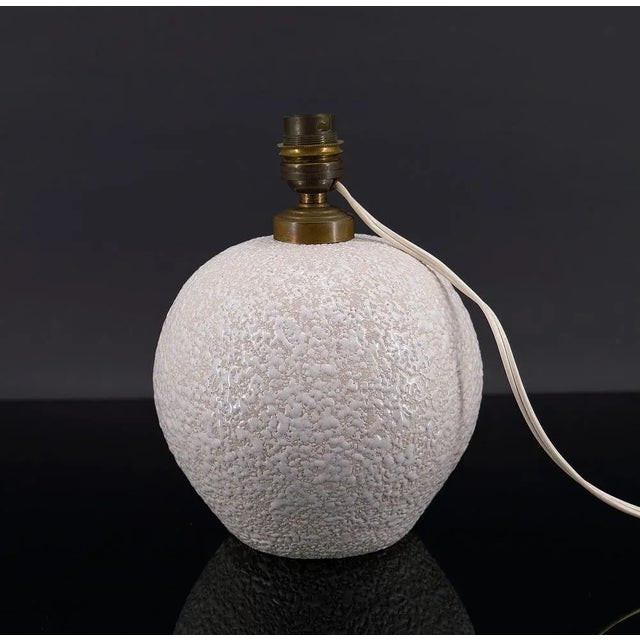 Elegant enameled ceramic ball table lamp. Spherical shape, with white enamel on a light cream background. Art Deco,...