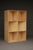 Minimalist object/artwork composed of a series of six plywood cubes with diagonal divisions inside reminiscent of Donald...