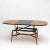Coffee table with oval table top and conical legs and x-shaped brace. By extending the table top and inserting a center...