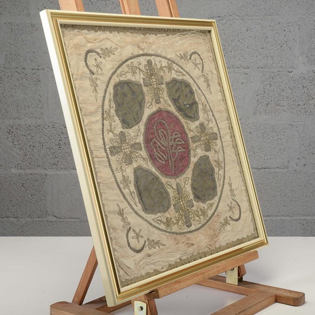 This framed antique textile artifact, dating from the 19th century, is crafted from a precious liturgical fabric or...