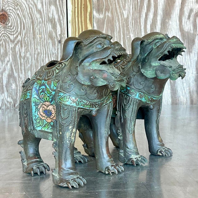Elevate your décor with a touch of exotic elegance and American sophistication. This pair of vintage Asian patinated Foo...