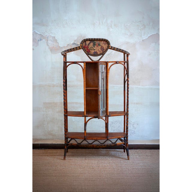 Rattan and Rush Étagère with Bevelled Glass Door – Dal Vera – 1910 Crafted in rattan and drawn and painted rush, featuring...