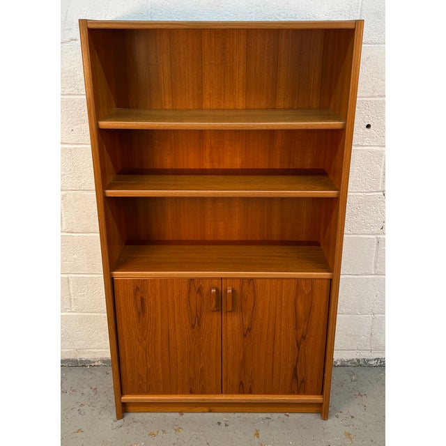 A beautifully crafted mid-century Danish modern bookcase in richly grained teak, offering the perfect balance of...