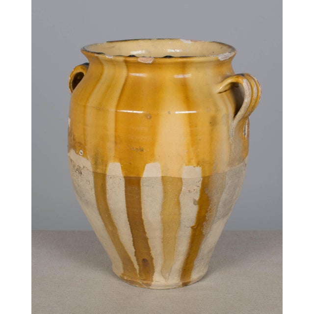 An earthenware confit pot from the Southwest of France with traditional yellow ochre drip glaze. Some losses to glaze....