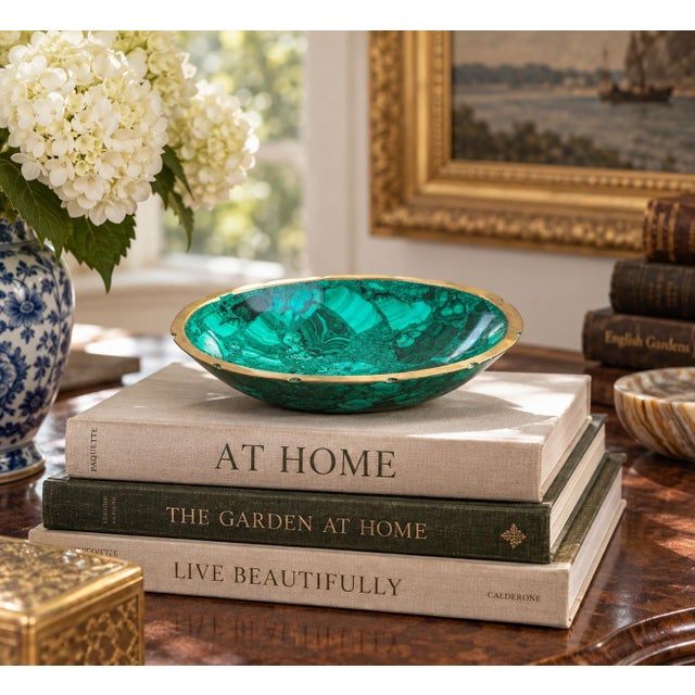 A beautifully proportioned brass rimmed malachite bowl in richly veined shades of green and black. The sculptural...