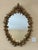 Mid-century Italian carved giltwood wall mirror by Florentia, featuring an exuberant stylized floral and leaf motif. A...