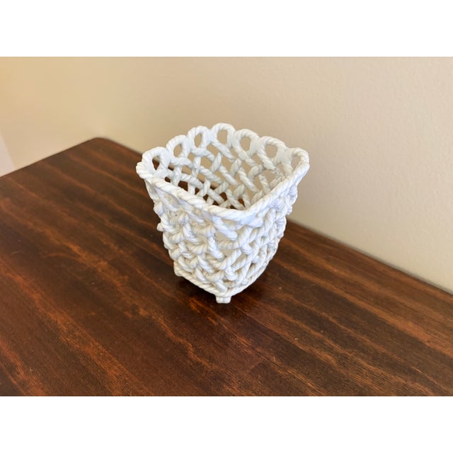 An elegant trompe l'oeil porcelain cachepot crafted in the form of a handwoven rope basket. Executed in glossy white...