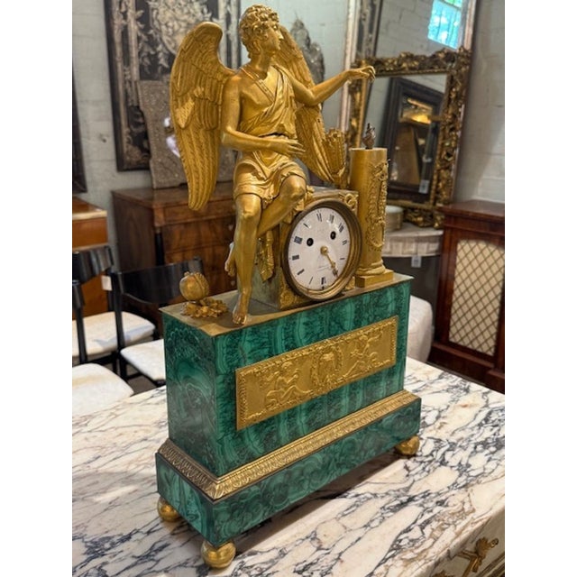 The "Period French Empire Malachite and Ormoro Figural Clock" is a stunning decorative collectible with a timeless design....